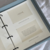 Fotoalbums "Bildē būt" ar gaiši zilu vāku un zelta vāka apdruku. Albumam ir magnētiska aizdare un melns metāla riņku mehānisms iekšlapu stiprināšanai.