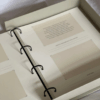 Fotoalbums "Bildē būt" ar bēšu vāku un melnu vāka apdruku. Albumam ir magnētiska aizdare un melns metāla riņku mehānisms iekšlapu stiprināšanai.